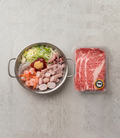 Packaged meat next to a bowl of ingredients on a gray surface