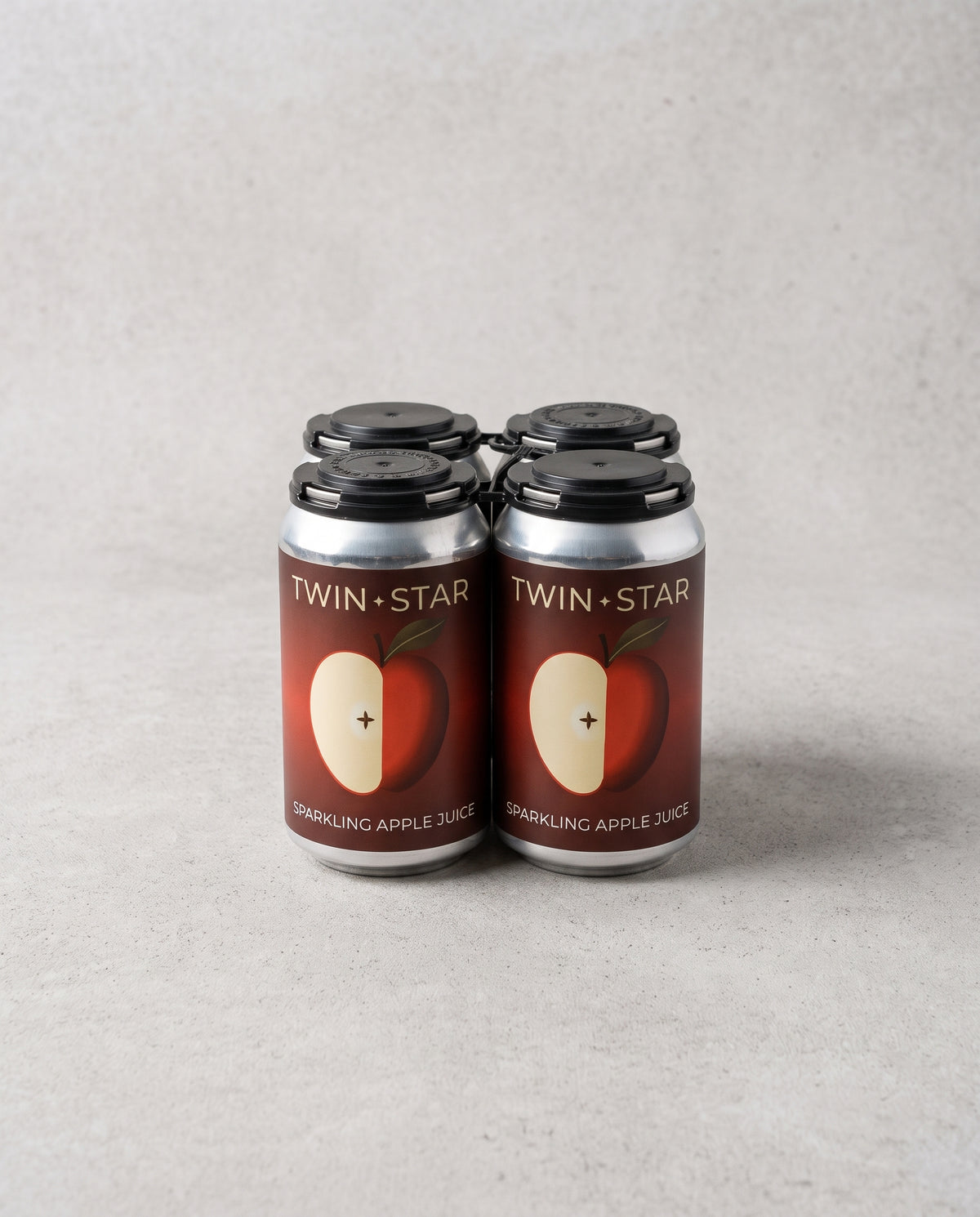 Four-pack of Twin Star Orchards sparkling apple cider cans with red apple labels and a black carrying handle.